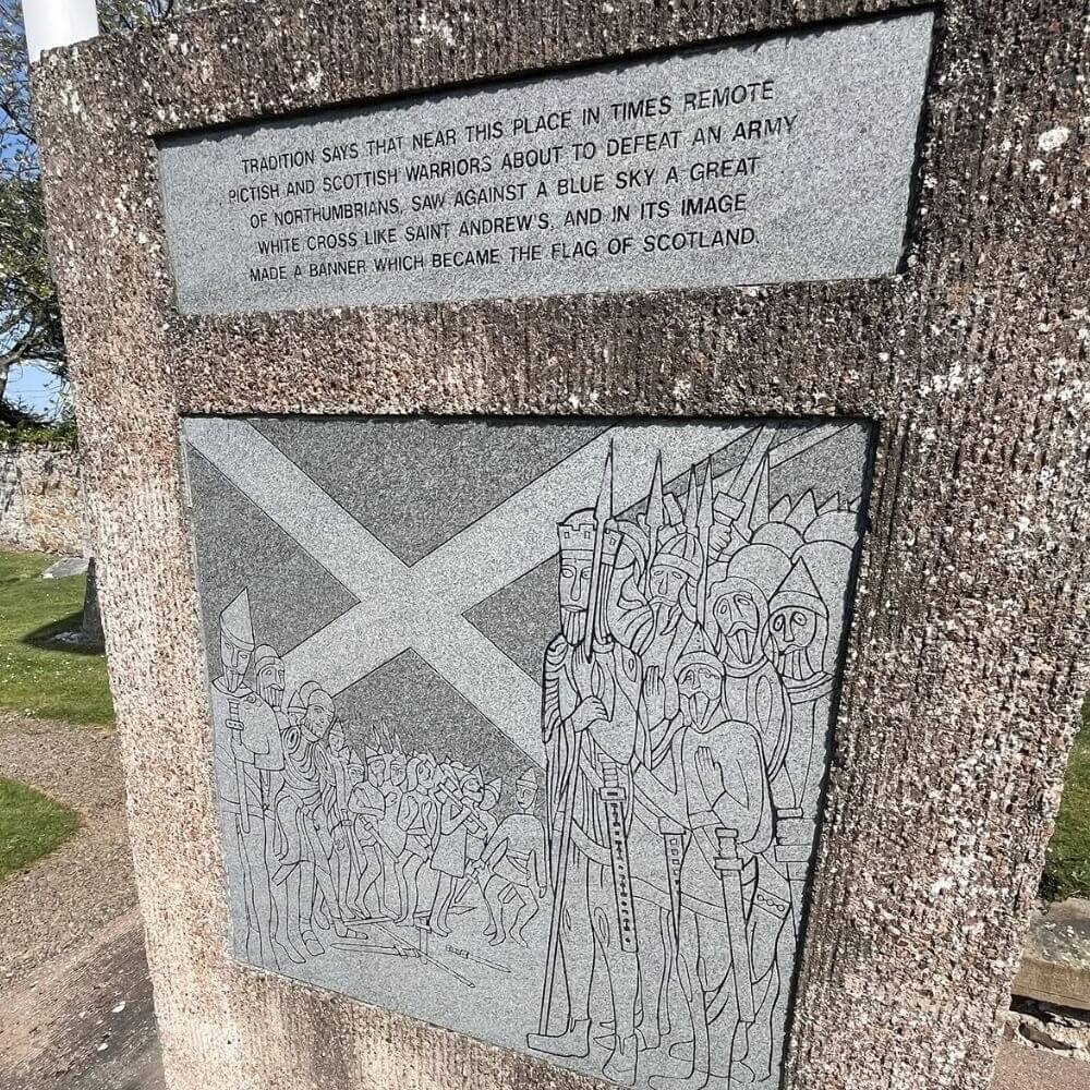Stone monument depicting a warrior and the Saltire, illustrating the battle legend where Scots saw the white cross in the sky.