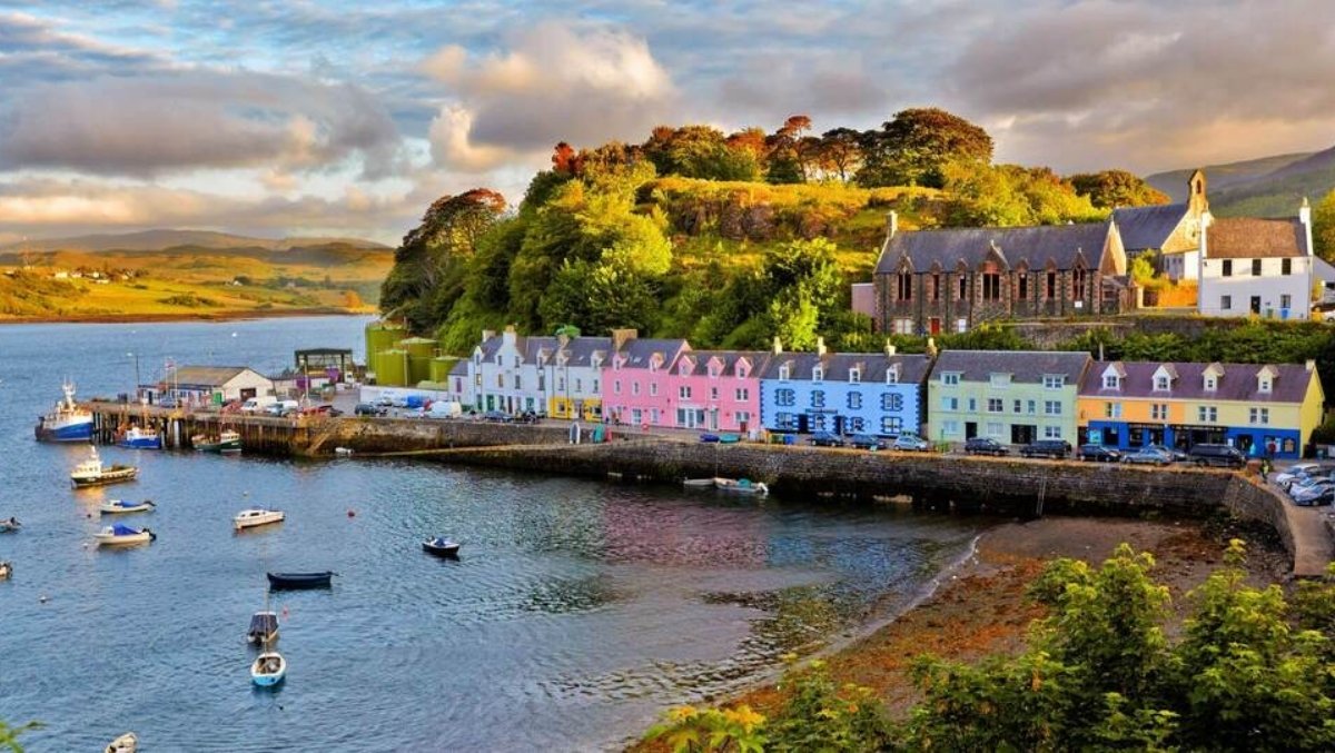 View of modern Oban with colorful waterfront houses and boats, showing the coastal setting that was historically strategic.