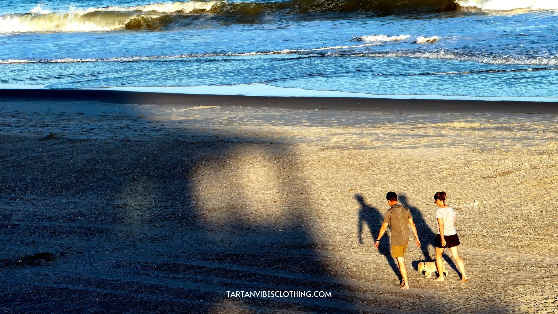 Emerald Isle, North Carolina, United States-June 26, 2021: A couple and their dog on an evening stroll along the beach