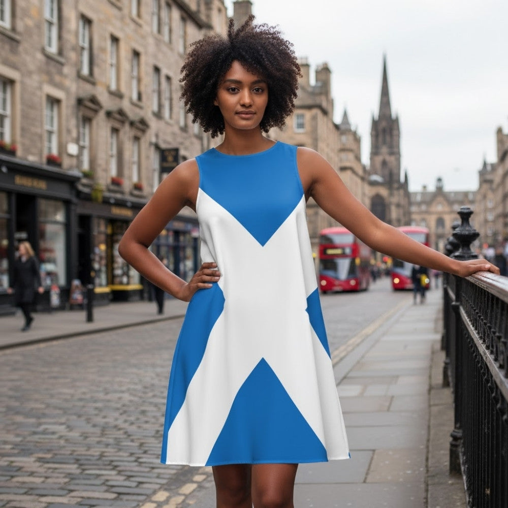 Woman standing on a city street wearing a blue-and-white dress styled with a Saltire cross pattern.