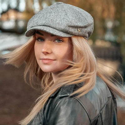 Woman wearing a grey herringbone baker boy cap with a full paneled crown