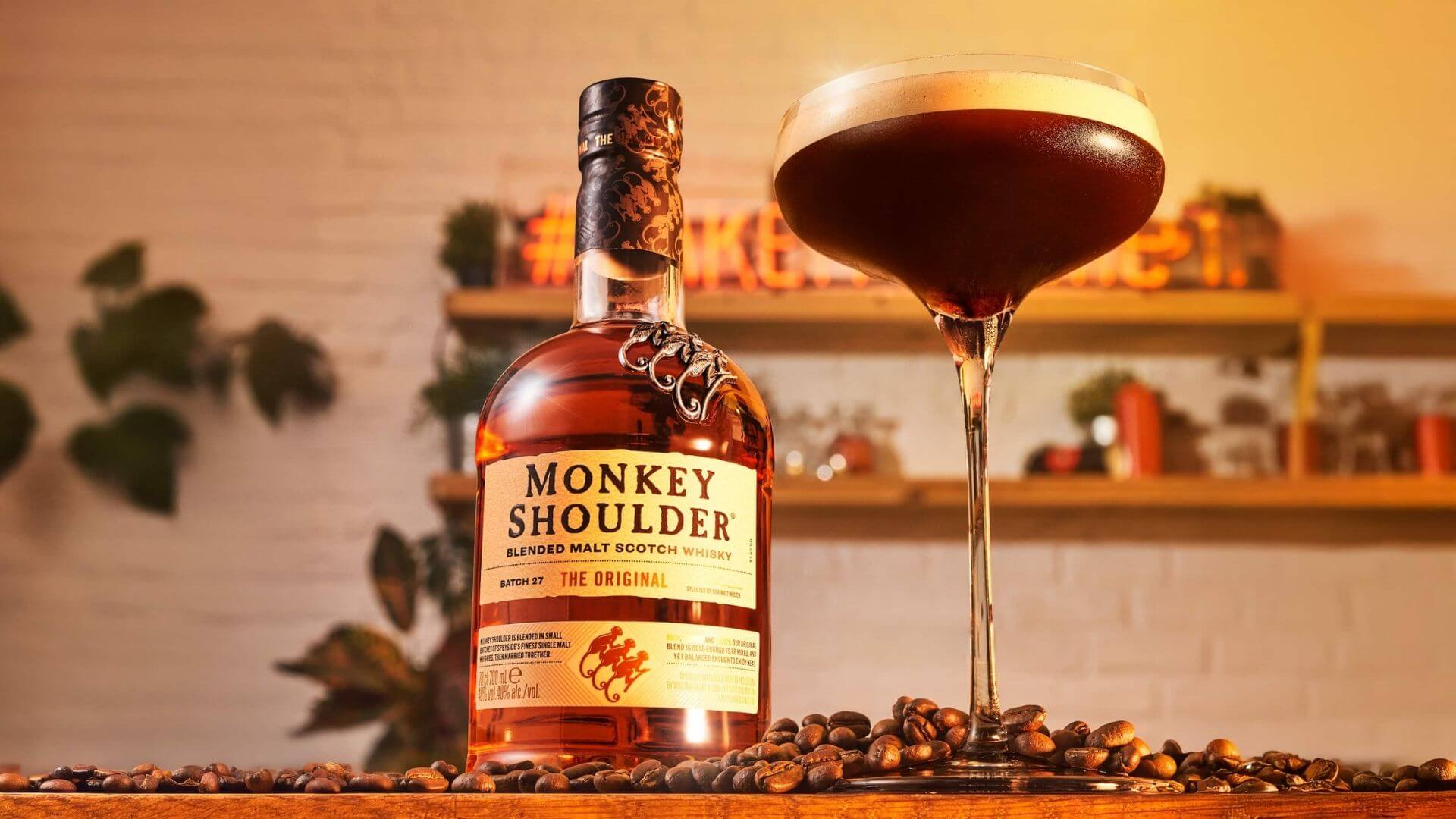 Monkey Shoulder blended malt Scotch whisky bottle with espresso-style whisky cocktail on bar