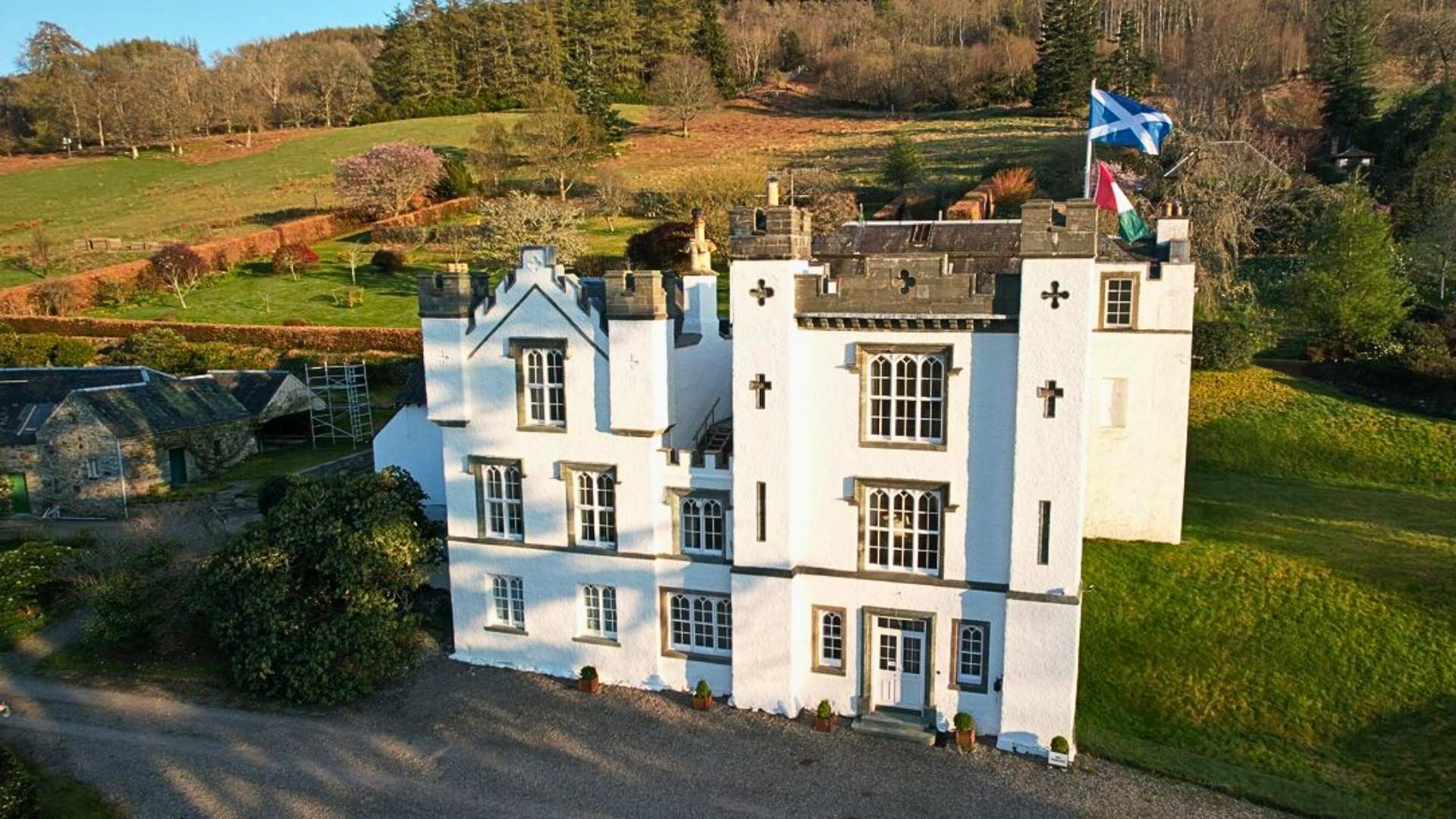 Bolfracks House in Perthshire, elegant white manor linked to Clan Menzies, with gardens and flags.