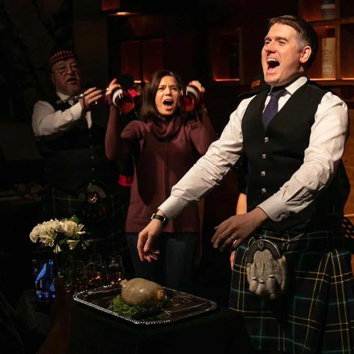 Burns supper guests address the haggis during a traditional Scottish celebration