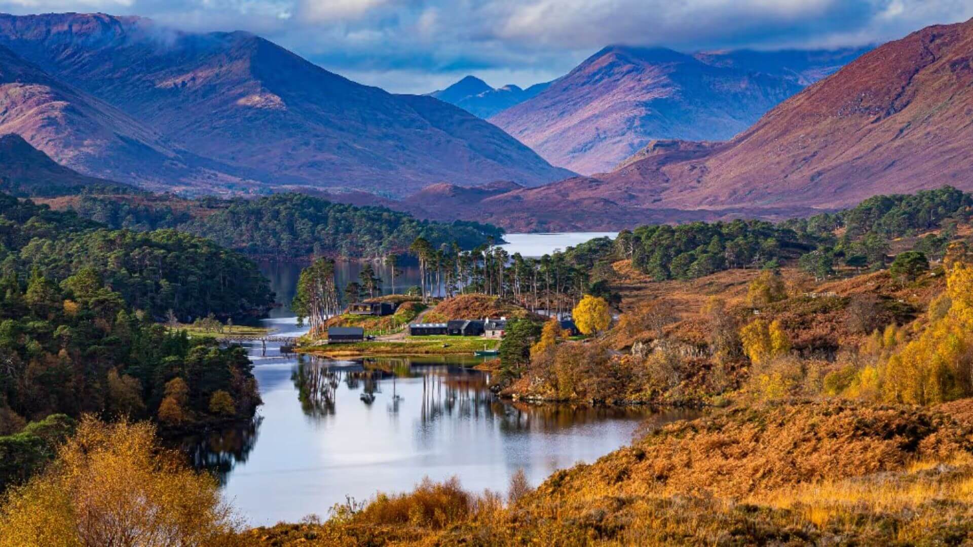 Scenic view of mountains, forests, and lochs in Cairngorms National Park, Scotland.