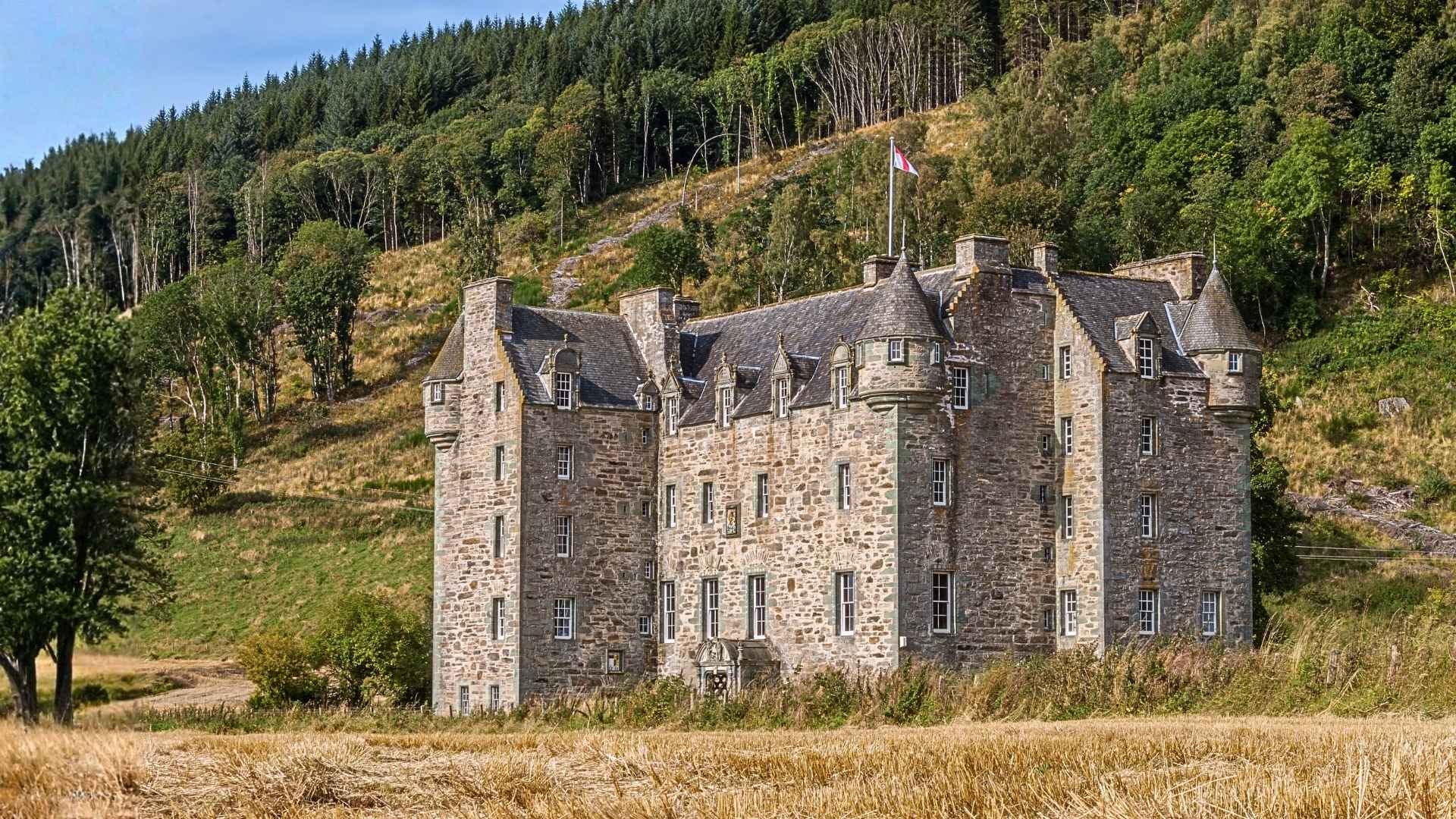 Castle Menzies in Perthshire, a 16th-century Scottish Renaissance castle amid Highland hills.