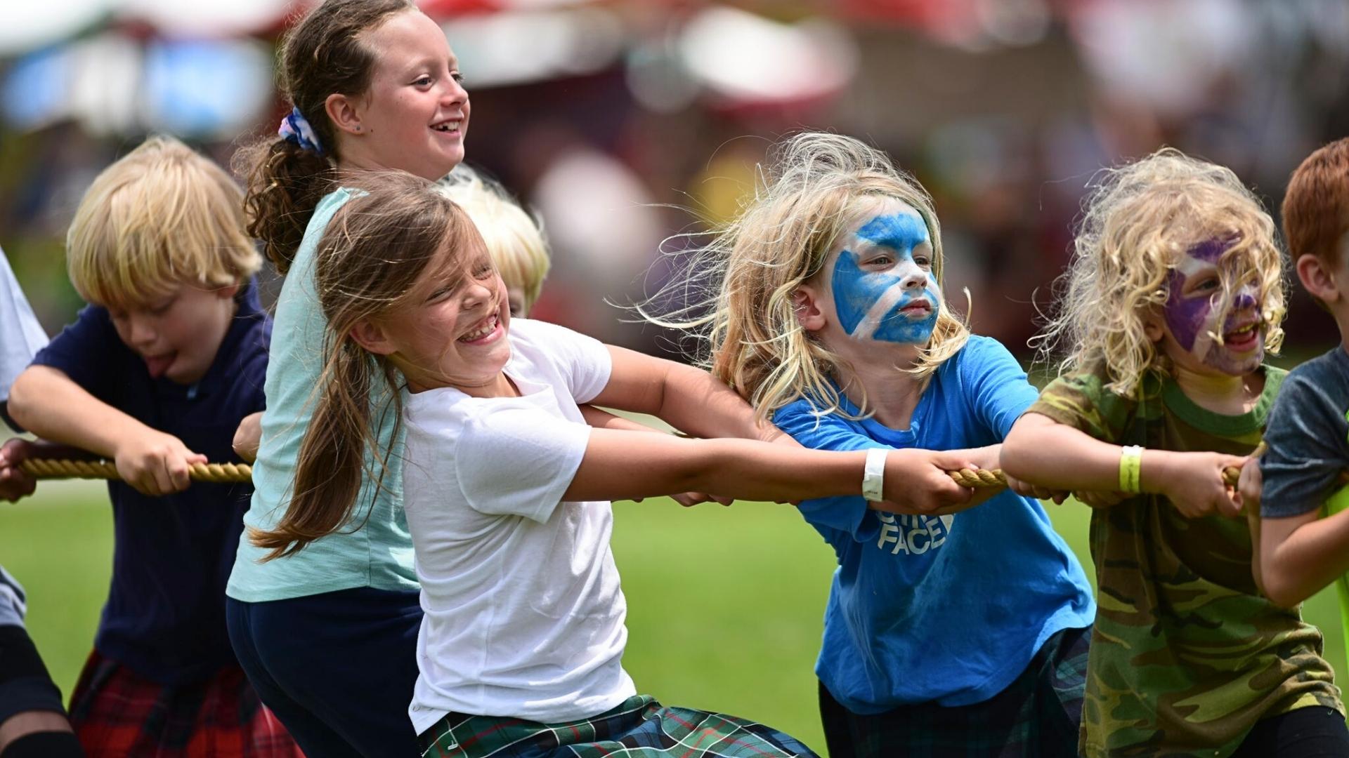 Children beam with excitement as they compete in a spirited tug-of-war at the Grandfather Mountain Highland Games.