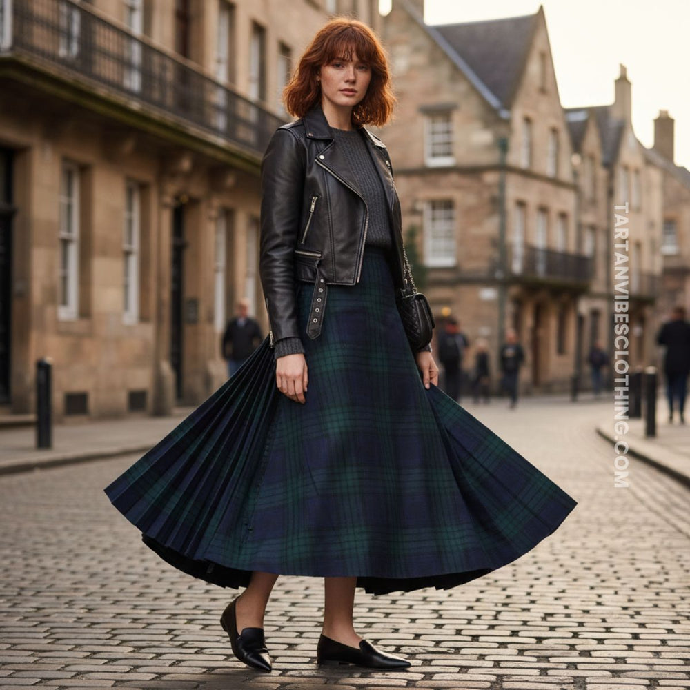 Woman wearing a tartan kilt maxi skirt with cropped leather jacket and sleek flats on a city street