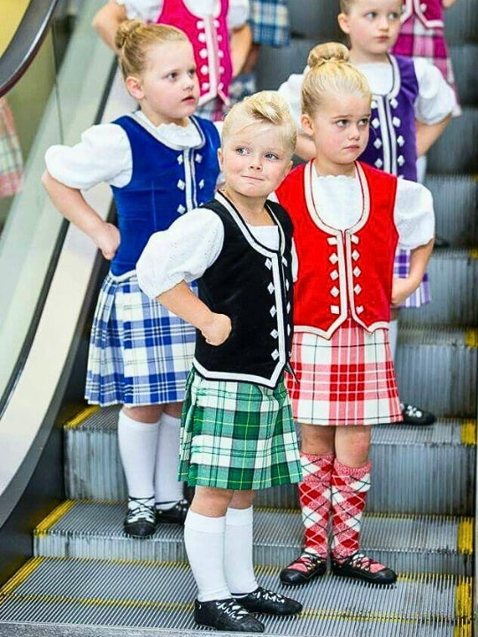 Highland dancer kids in tartan kilts and vests, proudly dressed in Scottish traditional attire.