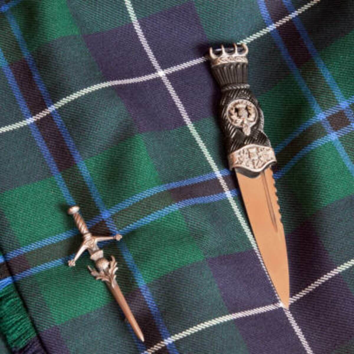 Sgian-dubh and kilt pin displayed on a tartan kilt in Highland dress
