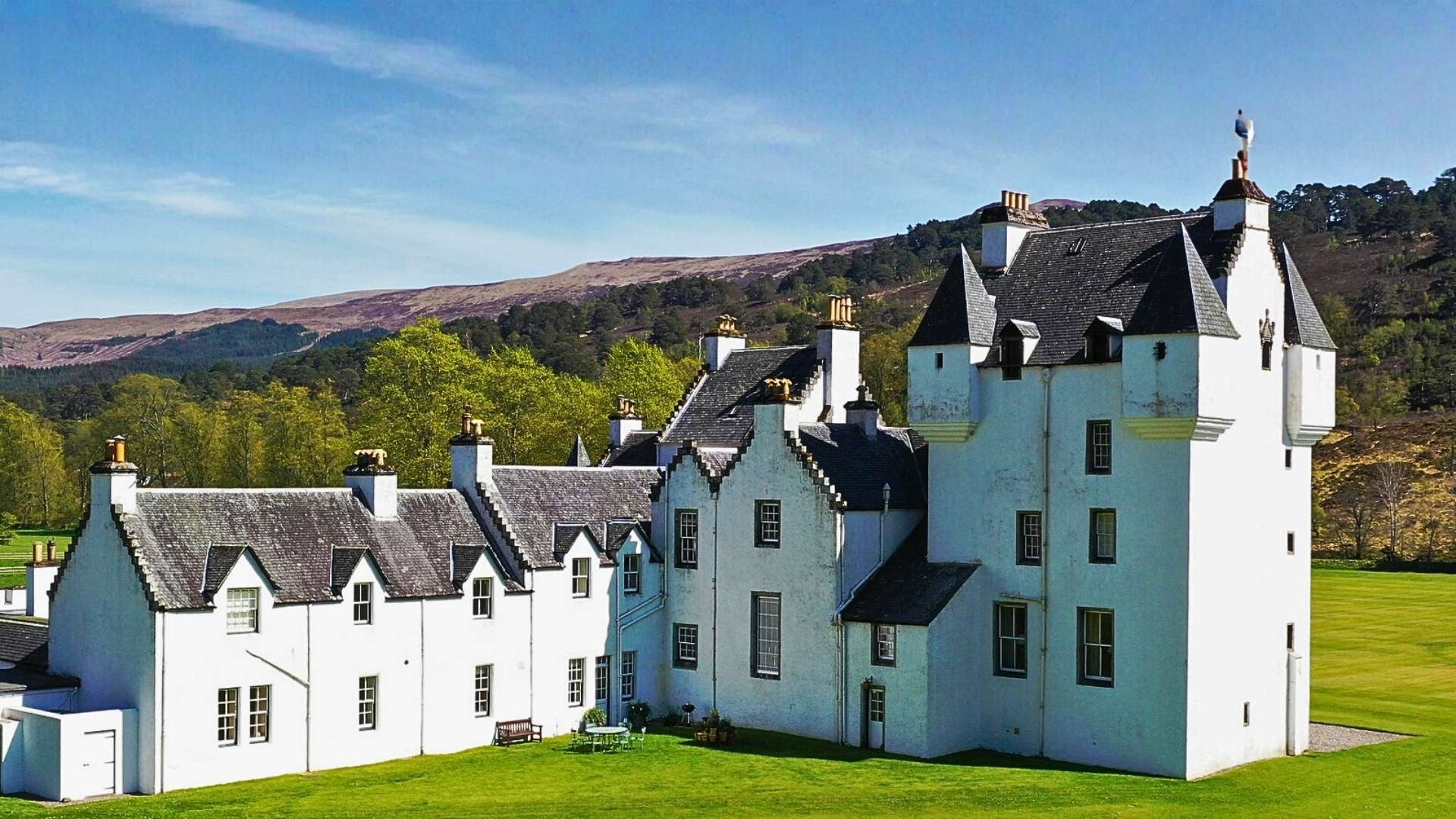 Meggernie Castle in Glen Lyon, white tower house of the Menzies of Culdares amid Highland hills.