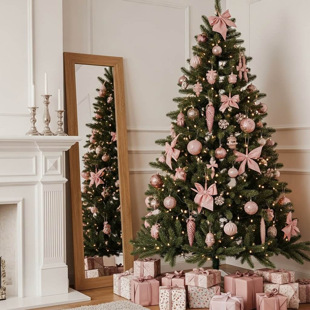 Elegant Christmas tree decorated with pink ornaments, bows, and twinkling lights beside a mirror and fireplace, surrounded by matching wrapped gifts.