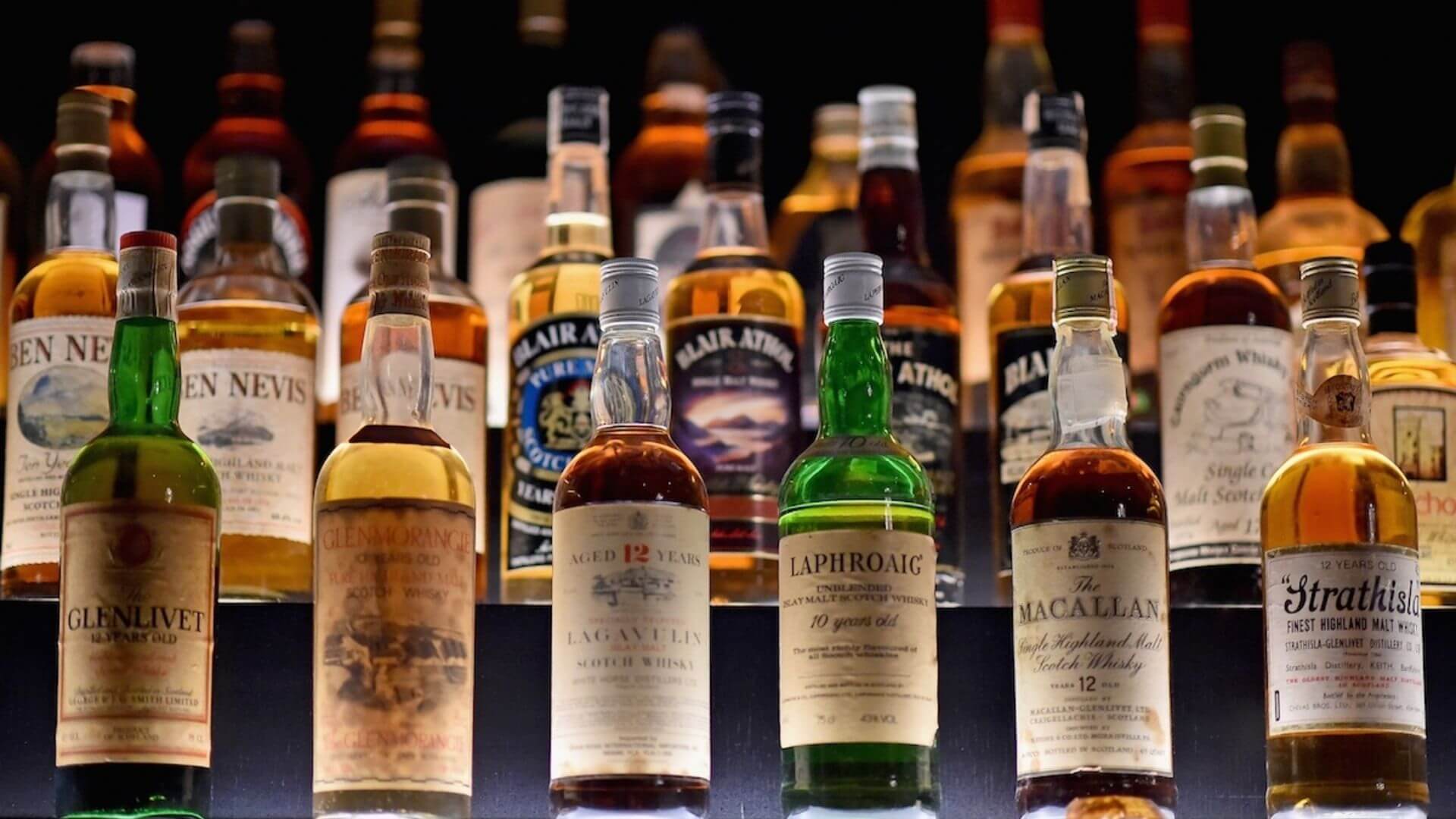 Collection of premium Scotch whisky bottles including Glenlivet, Macallan, Laphroaig, and Lagavulin on display