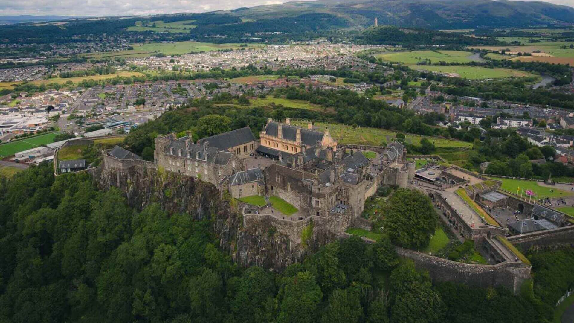 Aerial view of Stirling Castle surrounded by greenery and the Scottish countryside.