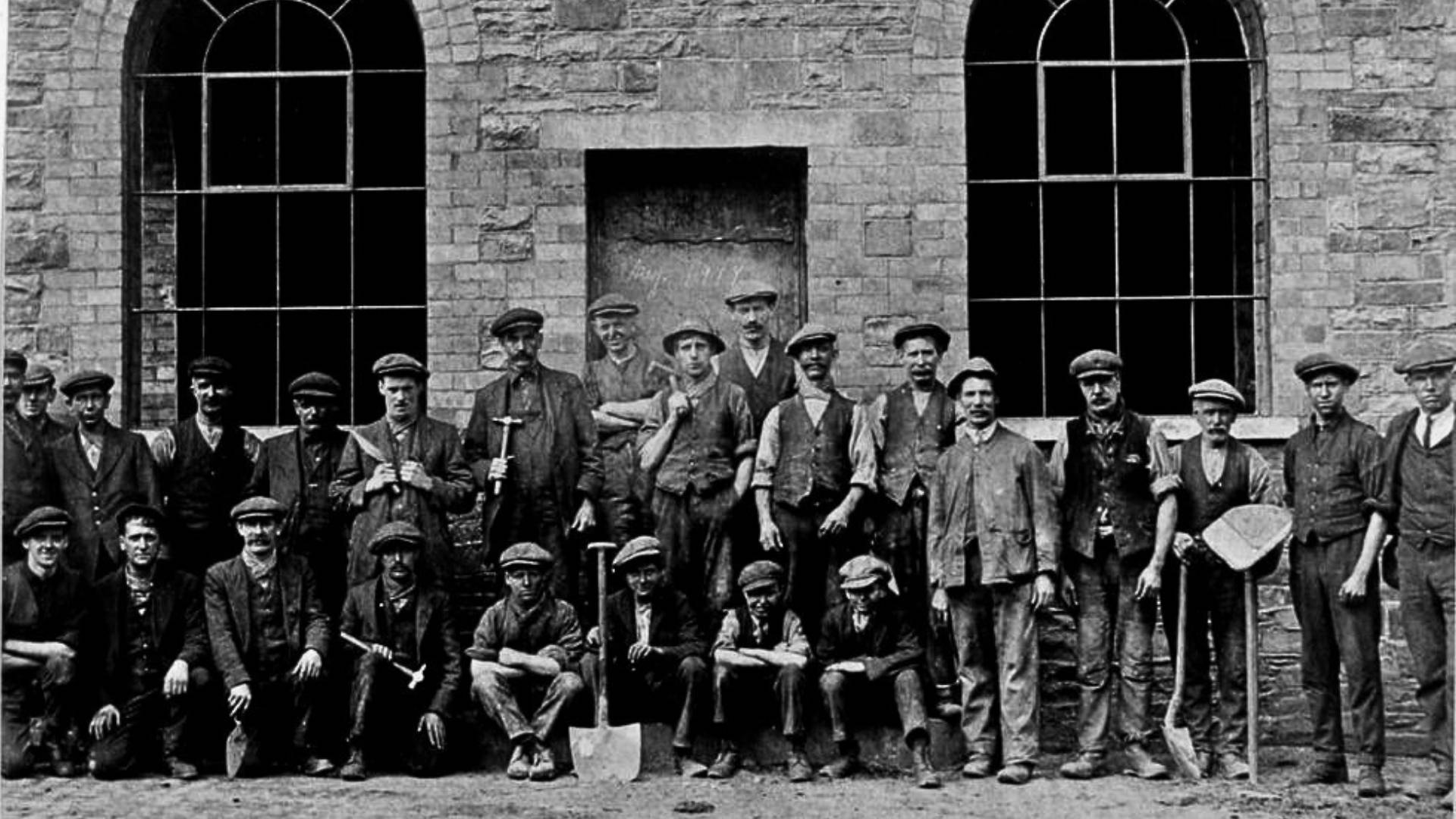 Welsh colliery workers wearing flat caps outside Lewis Merthyr Colliery
